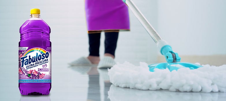 Persona trapeando el piso al fondo con Fabuloso Fresca Lavanda en primer plano