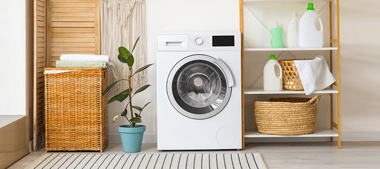 Cuarto de lavado equipado con lavadora, estantes organizados con ropa y envases de productos especiales para suavizar toallas