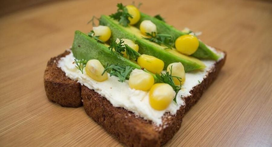Tostadas de queso crema, aguacate, maiz y perejil