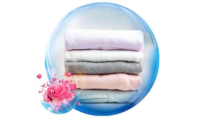 Pilas de toallas suaves y esponjosas en tonos pastel, destacando frescura, limpieza y un agradable perfume floral.