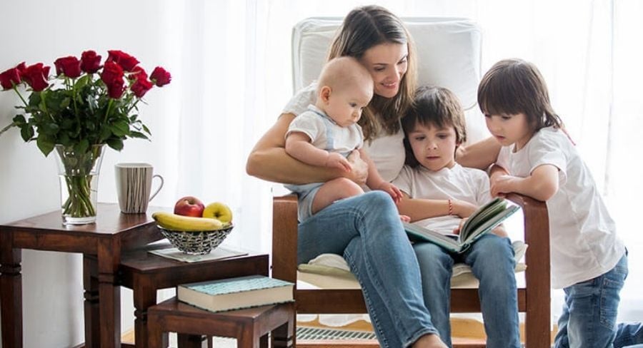 Mamá y sus hijos leyendo un cuento