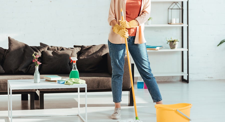 mujer trapeando el piso de la sala