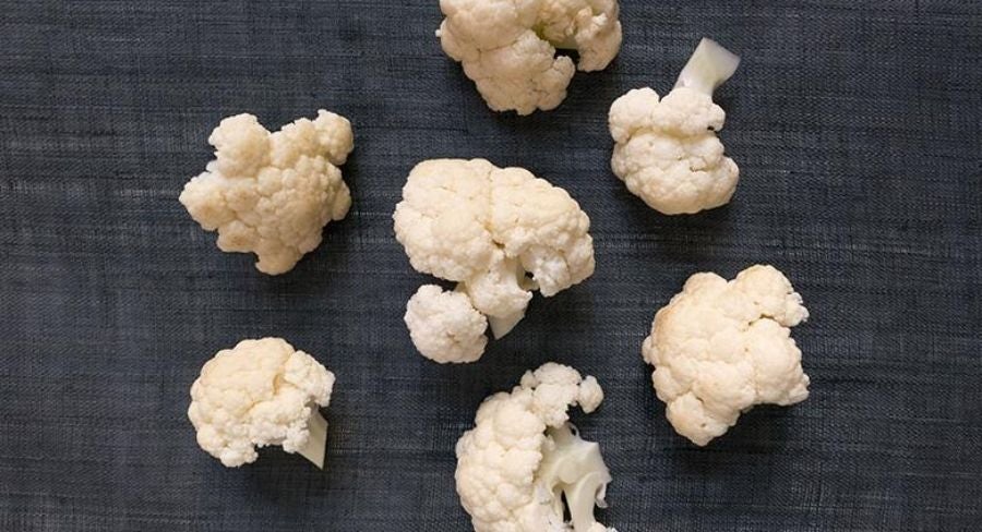 Preparación de nuggets de coliflor: Engrasa el papel para hornear con el aceite de coco. Distribuye muy bien. Precalienta el horno a 200 ºC.