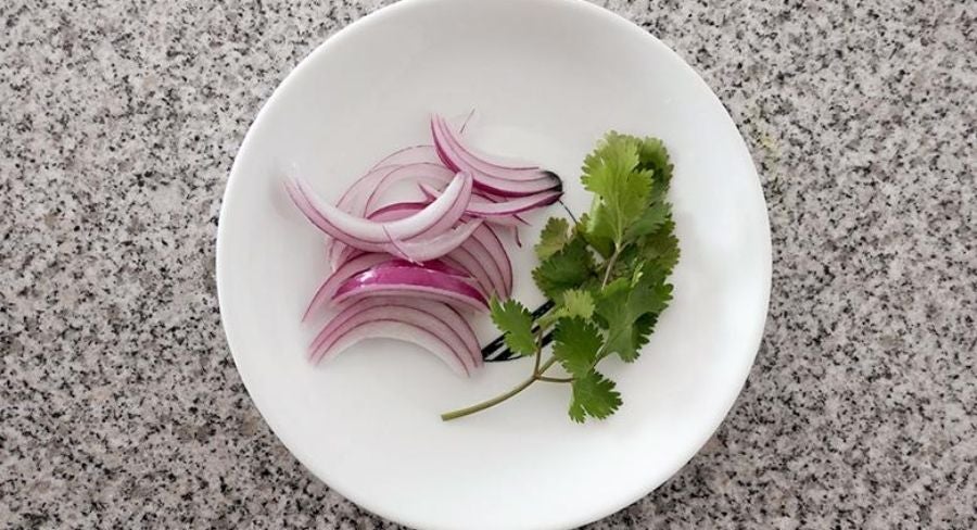 Proceso para preparar ensalada tailandesa de pepino: pica la cebolla y el cilantro y mézclalos con el pepino